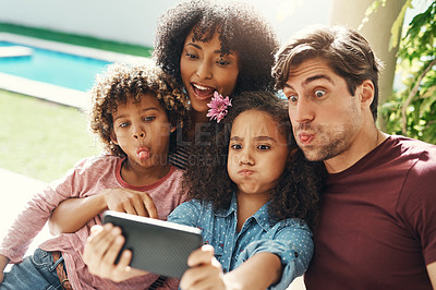 Buy stock photo Shot of a beautiful young family taking a selfie together outdoors