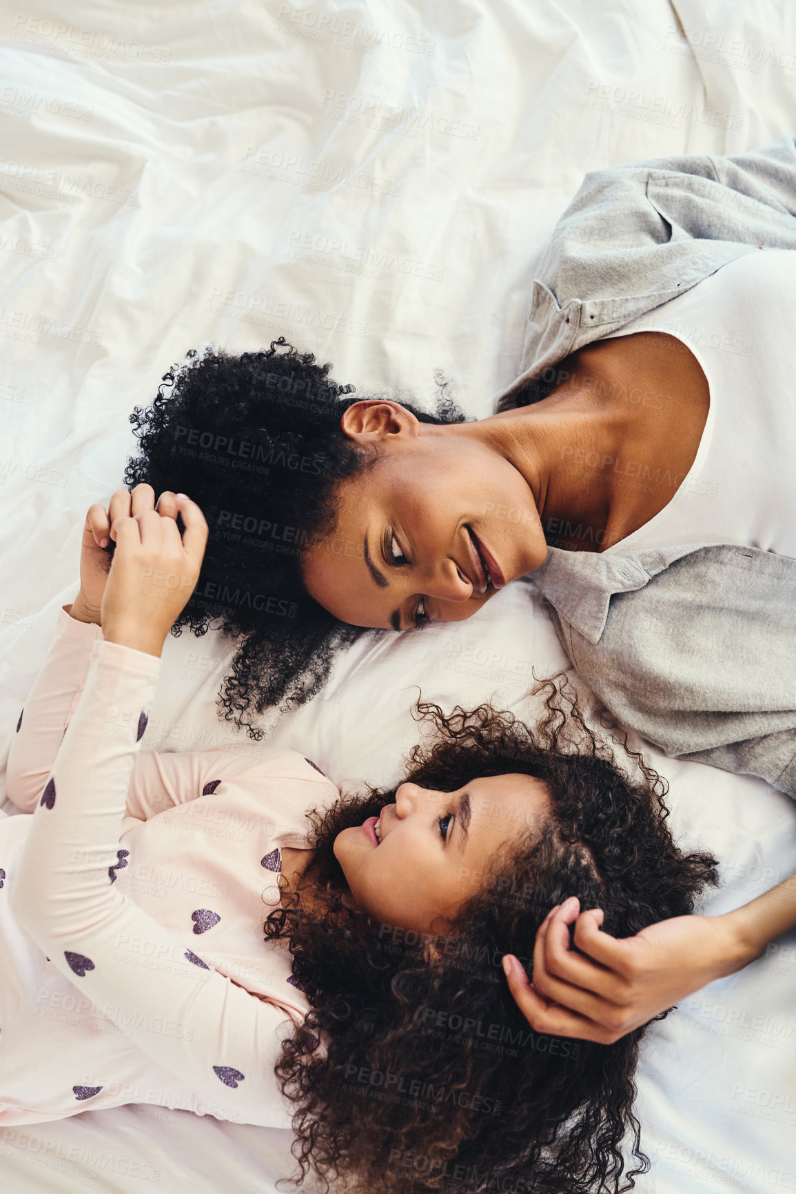 Buy stock photo Relax, love and mother with child on bed for bonding girl time and playing with hair at home. Happy, rest and black mom with kid in bedroom on weekend morning for laying together at family house.