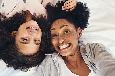 Buy stock photo High angle shot of a mother and her little daughter taking selfies together at home