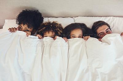 Buy stock photo Portrait of a family lying down in bed together at home