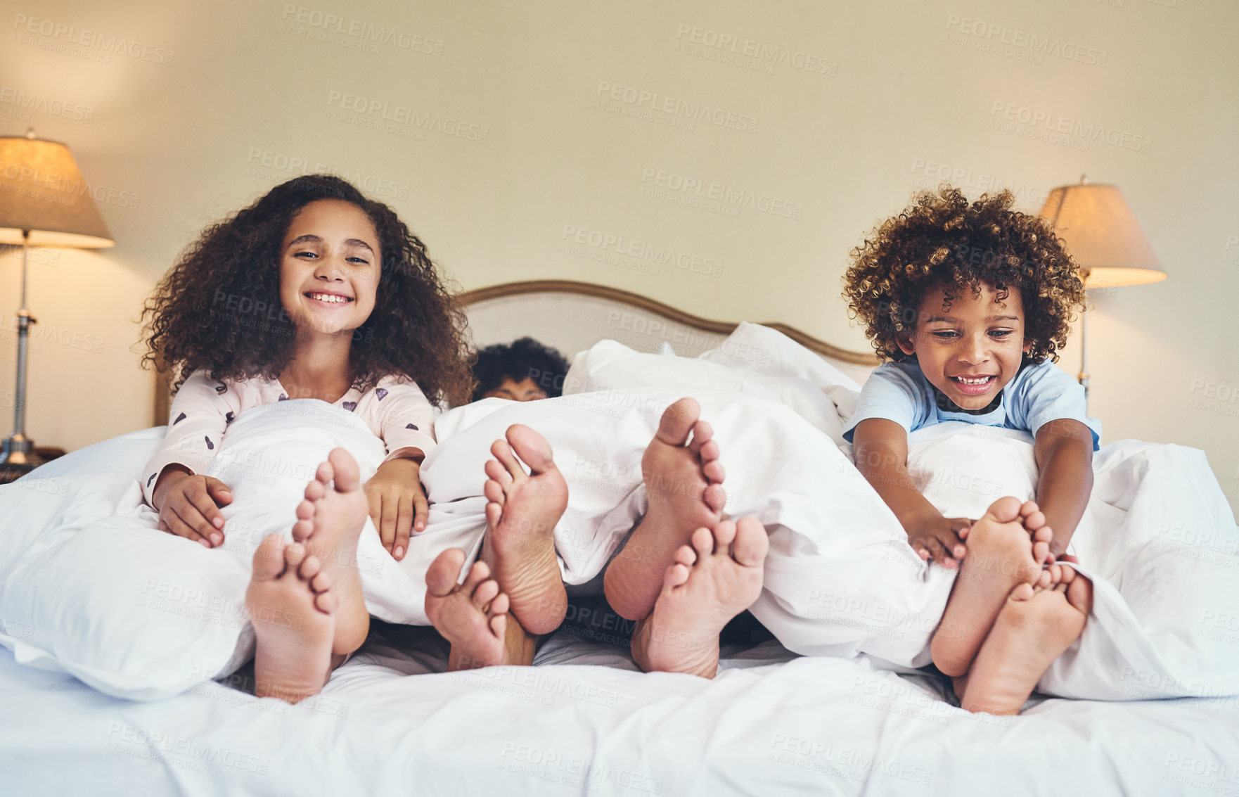 Buy stock photo Portrait of two adorable little children relaxing in bed with their parents at home