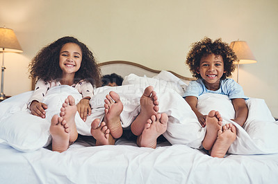 Buy stock photo Portrait of two adorable little children relaxing in bed with their parents at home