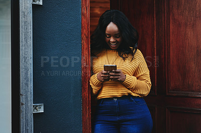 Buy stock photo Door, phone and woman on social media, texting and happy while reading message in front of house. Smartphone, influencer and african female online for blog, networking or accommodation app review