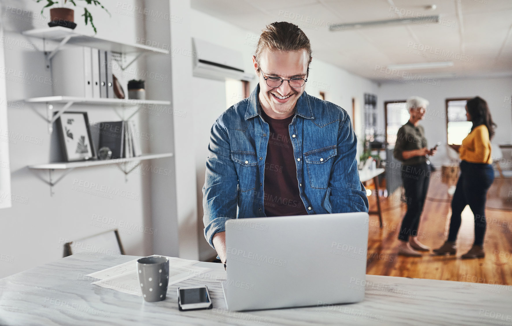 Buy stock photo Cropped shot of a handsome young businessman working on his laptop in the office