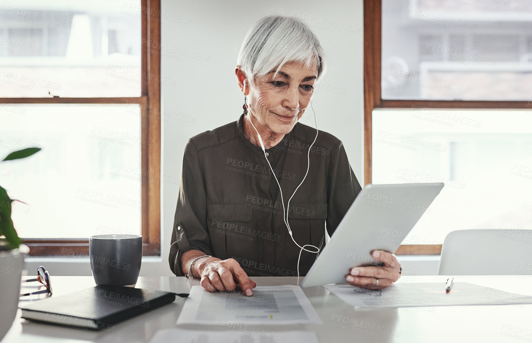 Buy stock photo Cropped shot of an attractive mature businesswoman working on her tablet in the office