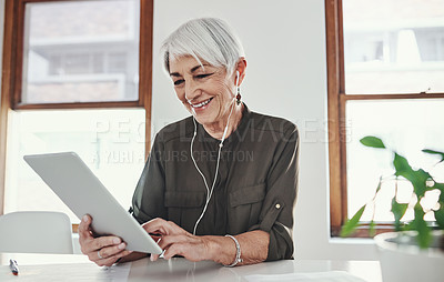 Buy stock photo Cropped shot of an attractive mature businesswoman working on her tablet in the office