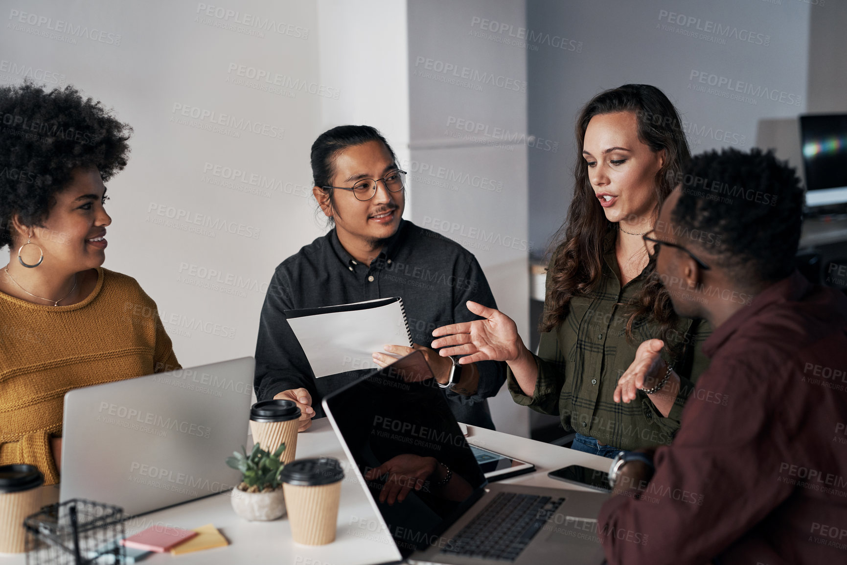 Buy stock photo Cropped shot of a diverse group of businesspeople sitting and having a meeting while using technology in the office