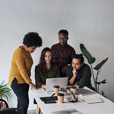 Buy stock photo Cropped shot of a diverse group of businesspeople working on a laptop together in the office