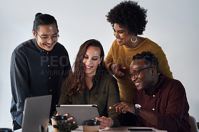 Buy stock photo Cropped shot of a diverse group of businesspeople working on a tablet together in the office