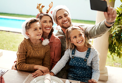 Buy stock photo Cropped shot of a family of four taking a selfie together on Christmas day