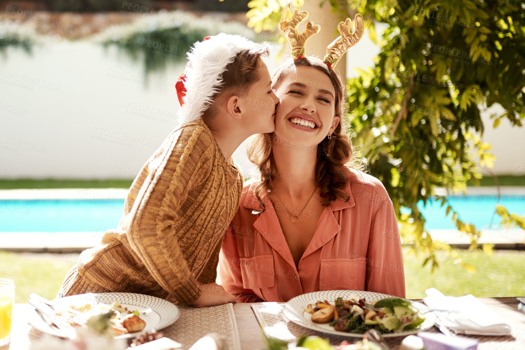 Buy stock photo Cropped shot of a girl girl and her mother enjoying Christmas lunch together