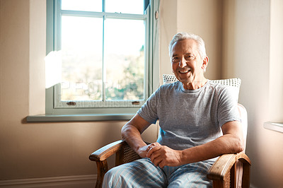 Buy stock photo Cropped portrait of a happy senior man sitting in an armchair in his nursing home during the morning
