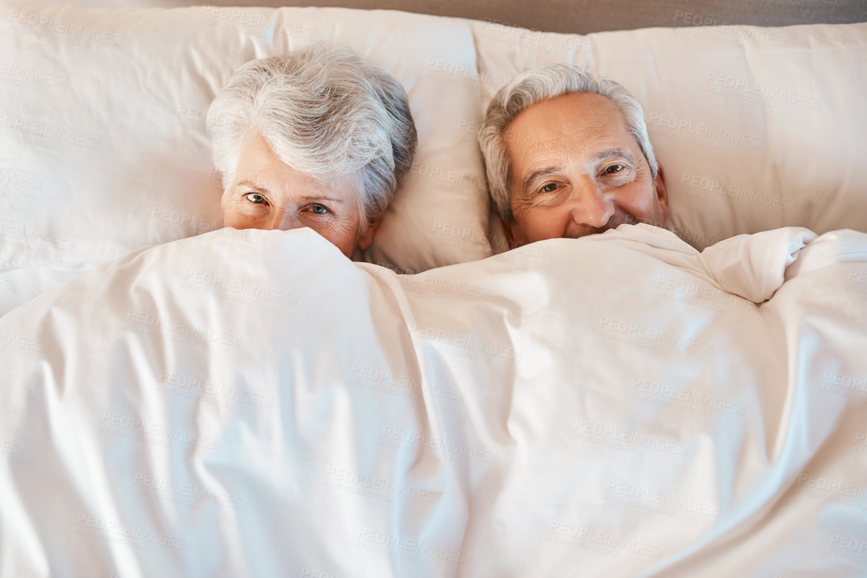 Buy stock photo Hide, bed and portrait of senior couple relaxing in home together for sleeping late in morning. Happy, love and elderly man and woman in retirement with blanket for comfortable in bedroom of house.