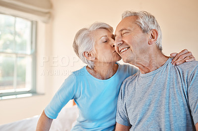 Buy stock photo Cropped shot of an affectionate senior woman kissing her happy husband on the cheek in a nursing home