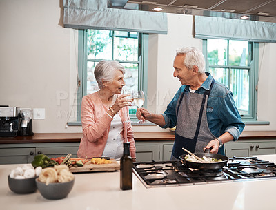 Buy stock photo Cheers, wine and elderly couple in kitchen cooking healthy dinner together with bonding. Love, happy and senior man and woman in retirement with alcohol drink for preparing food for supper in home.