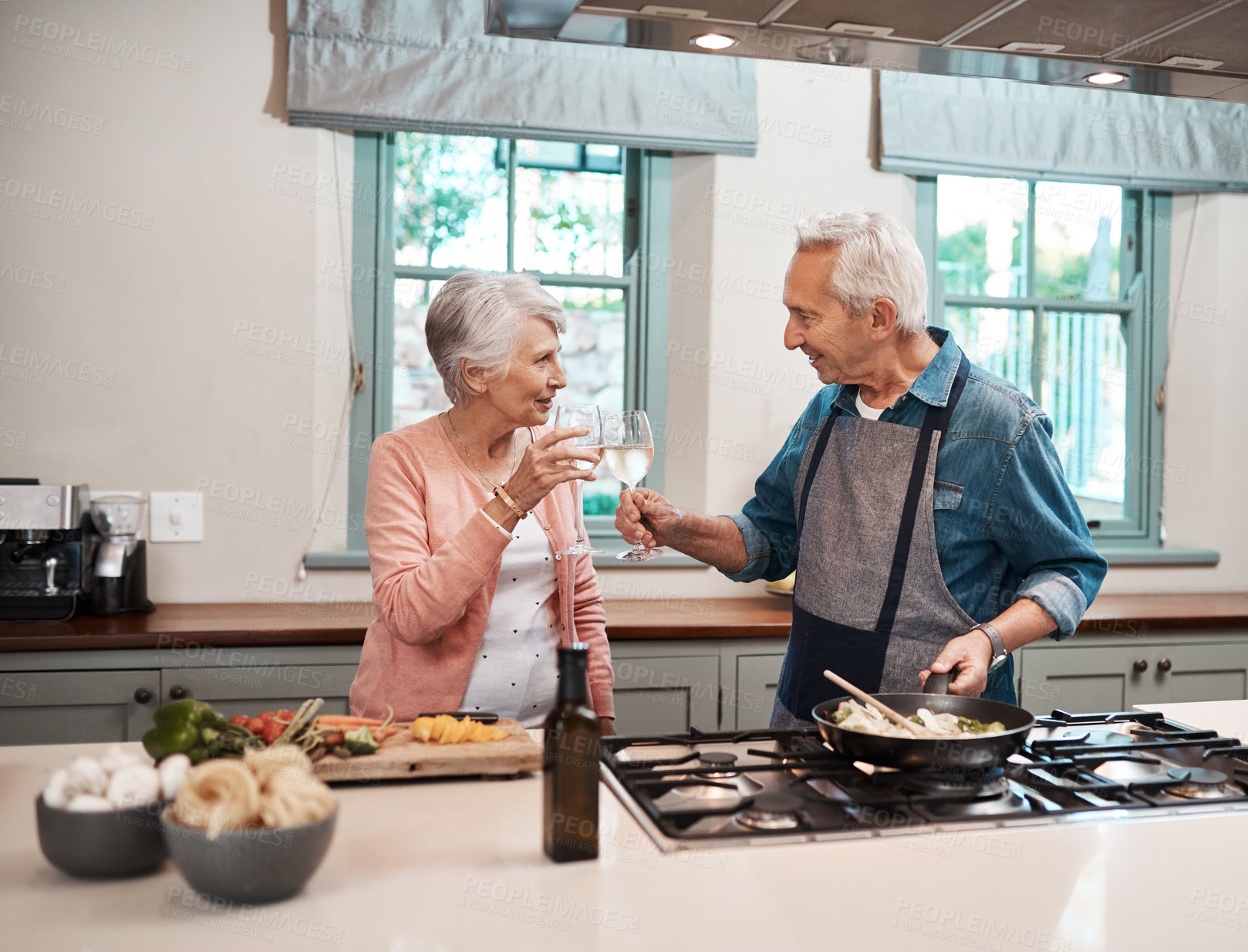 Buy stock photo Cheers, wine and elderly couple in kitchen cooking healthy dinner together with bonding. Love, happy and senior man and woman in retirement with alcohol drink for preparing food for supper in home.