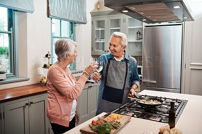 Buy stock photo Cropped shot of a couple making a toast while cooking in the kitchen
