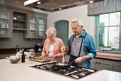 Buy stock photo Cropped shot of a senior couple cooking together at home