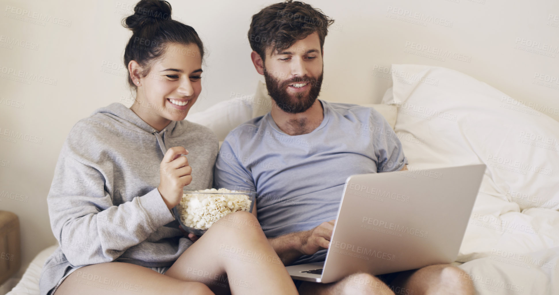 Buy stock photo Couple, laptop and smile in bed for popcorn, online and streaming in apartment, relax and watch of show. Weekend, home and hungry for food, man and woman with computer for video, bonding and love