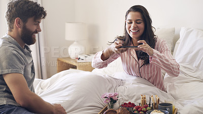 Buy stock photo Shot of a young woman taking a picture of the breakfast her husband has served her in bed