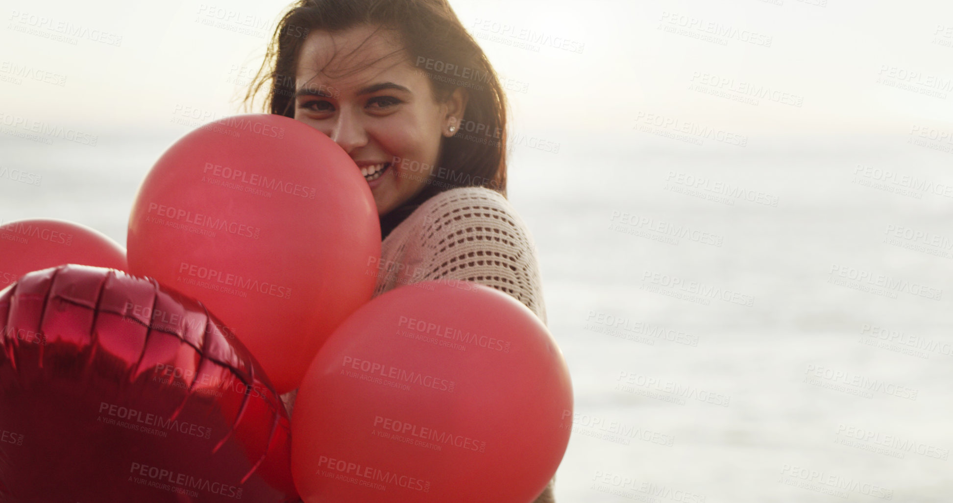 Buy stock photo Cropped shot of a beautiful young woman holding a bunch of balloons
