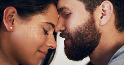 Buy stock photo Shot of an affectionate young couple sharing a romantic moment in the bedroom at home