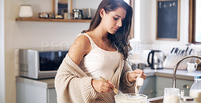 Buy stock photo Shot of an attractive young woman preparing breakfast at home