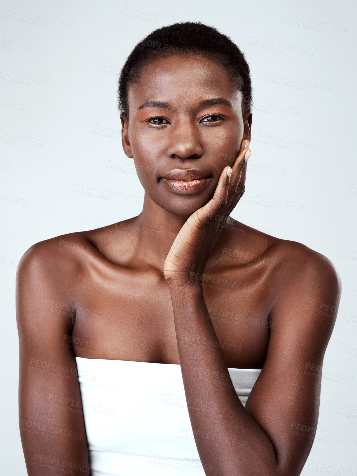 Buy stock photo Studio portrait of a beautiful young woman feeling her skin against a grey background