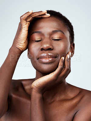 Buy stock photo Studio shot of a beautiful young woman feeling her skin against a grey background