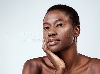 Buy stock photo Studio shot of a beautiful young woman looking thoughtful against a grey background