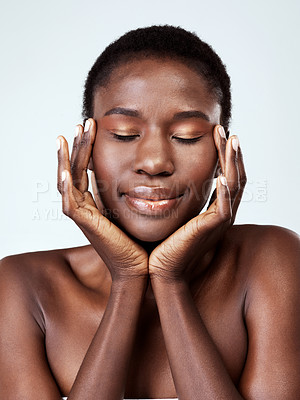 Buy stock photo Studio shot of a beautiful young woman feeling her skin against a grey background