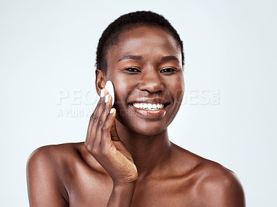 Buy stock photo Studio portrait of a beautiful young woman wiping her face with cotton