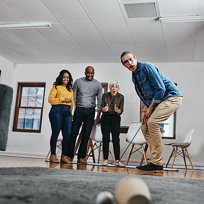 Buy stock photo Full length shot of a businessman playing golf in his office with his colleagues rooting for him in the background
