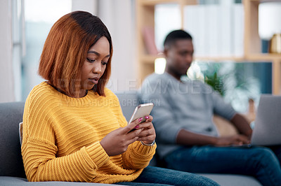 Buy stock photo Relax, phone or technology addiction and a woman on a sofa in the living room of her home with her boyfriend on a blurred background. Mobile, contact and social media with a female person in a house