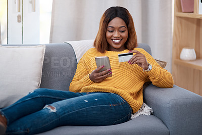 Buy stock photo Shot of an attractive young woman using a credit card while browsing online