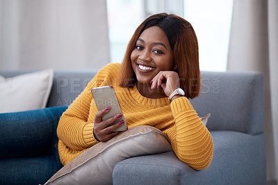 Buy stock photo Black woman using phone, chat on social media and relax at home, smile in portrait with online communication. African female person, mobile app with text or post update with connectivity in apartment