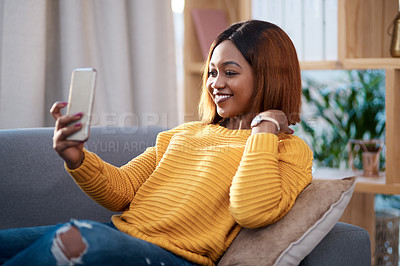 Buy stock photo Black woman in her home, selfie and relax on couch in living room, lifestyle influencer and social media post. African female content creator in apartment, smile in picture and communication with app