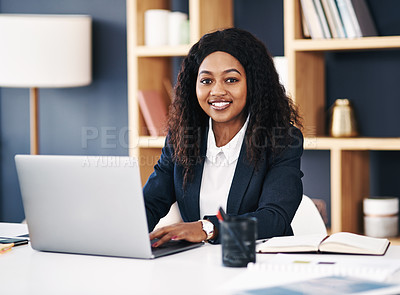 Buy stock photo Shot of a young businesswoman using a laptop at her desk in a modern office