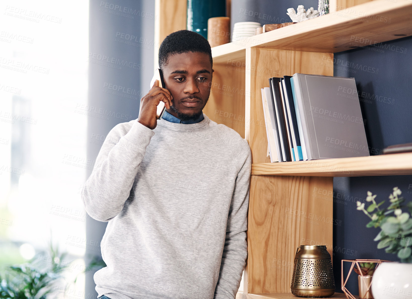 Buy stock photo Shot of a young businessman using a smartphone in a modern office