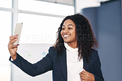 Buy stock photo Shot of a young businesswoman taking a selfie with a smartphone in a modern office