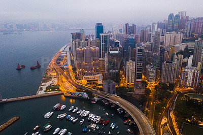 Buy stock photo Buildings, ocean and aerial view of the city at night with lights, boats and ships on the sea harbor. Landscape, architecture and drone of an urban town with skyscrapers, yachts and infrastructure.