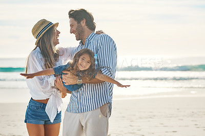 Buy stock photo Cropped shot of an affectionate couple playing with their daughter during an enjoyable day out on the beach