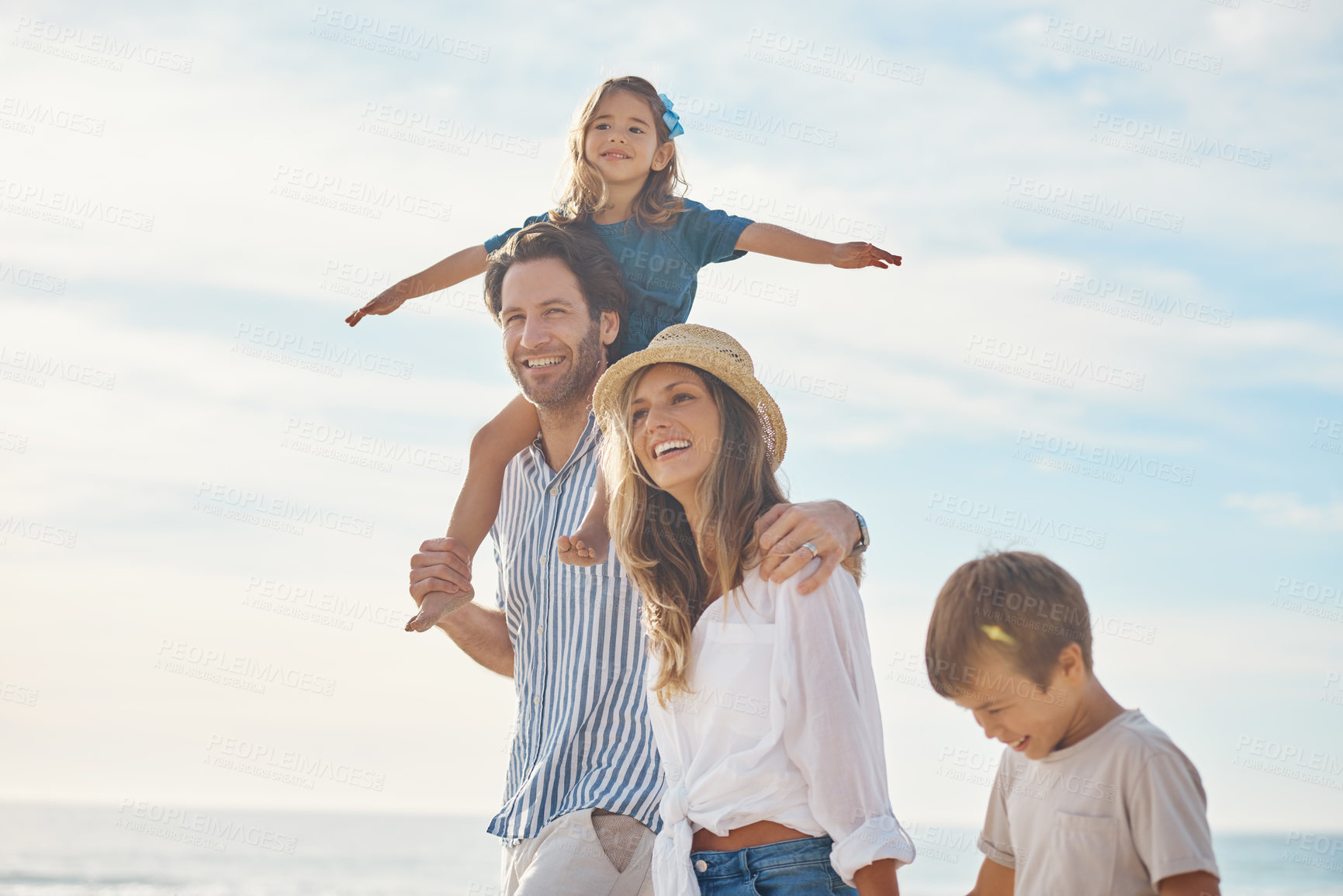 Buy stock photo Cropped shot of a happy couple bonding with their two children during a day out on the beach together