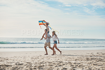 Buy stock photo Rearview shot of an unrecognizable father carrying his son on his shoulders and walking on the beach with his wife