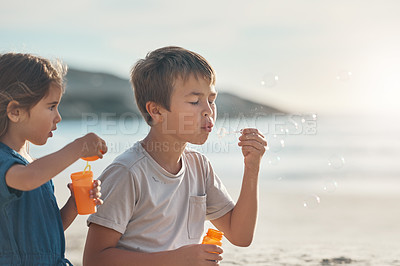 Buy stock photo Vacation, boy and girl with bubbles on beach for playing, summer fun and seaside game on holiday with fun. Children, siblings and together for travel adventure, childhood memories and bonding.