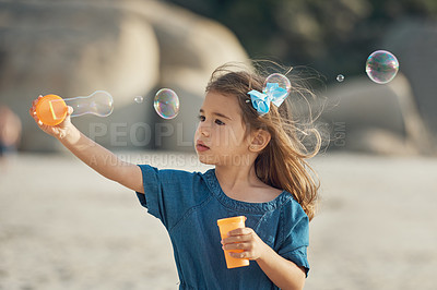 Buy stock photo Beach, bubbles and blow of girl for playful, development and entertainment for childhood outdoor. Physical activity, imagination and creativity of kid with plastic toy, soap and movement in ocean