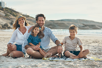 Buy stock photo Full length portrait of an affectionate couple sitting with their two children and enjoying a day on the beach together