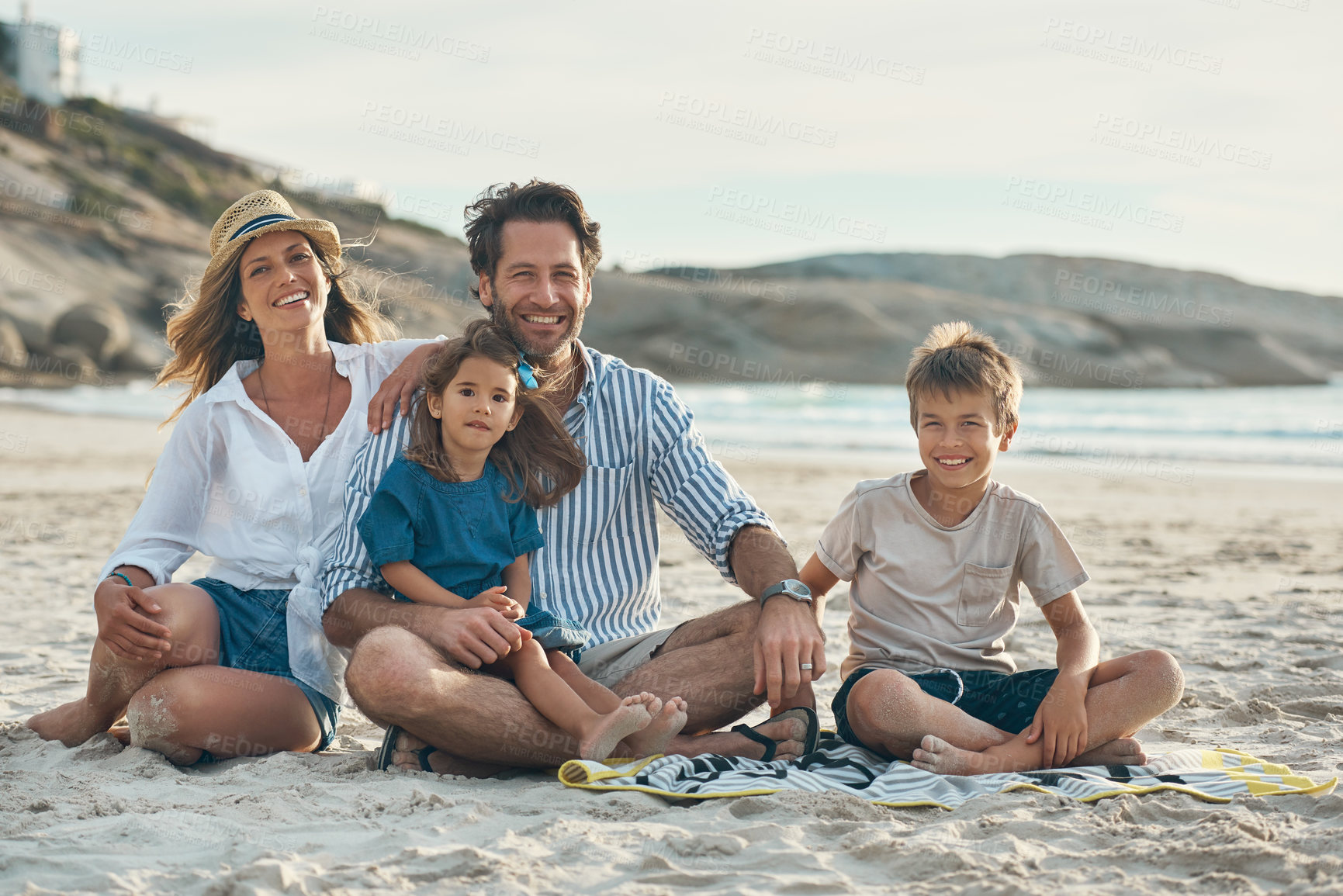 Buy stock photo Family, portrait and relax on beach sand for travel, holiday and bonding together in summer while carrying. Mom, dad and kids by ocean for fun trip, vacation and sunshine with happiness and love
