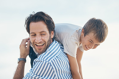Buy stock photo Cropped shot of a handsome mature father bonding with his son and carrying him on his shoulders on the beach