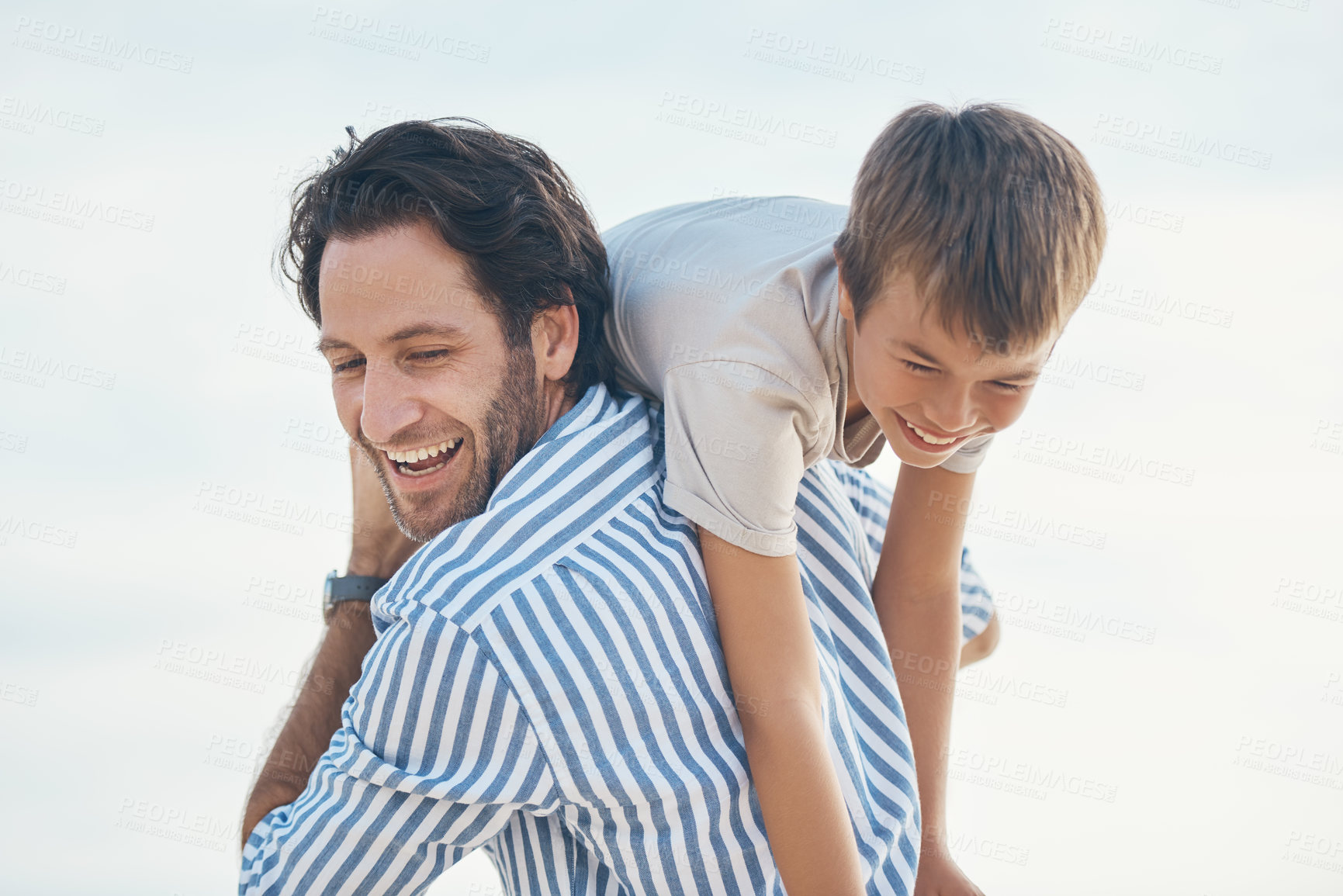 Buy stock photo Cropped shot of a handsome mature father bonding with his son and carrying him on his shoulders on the beach
